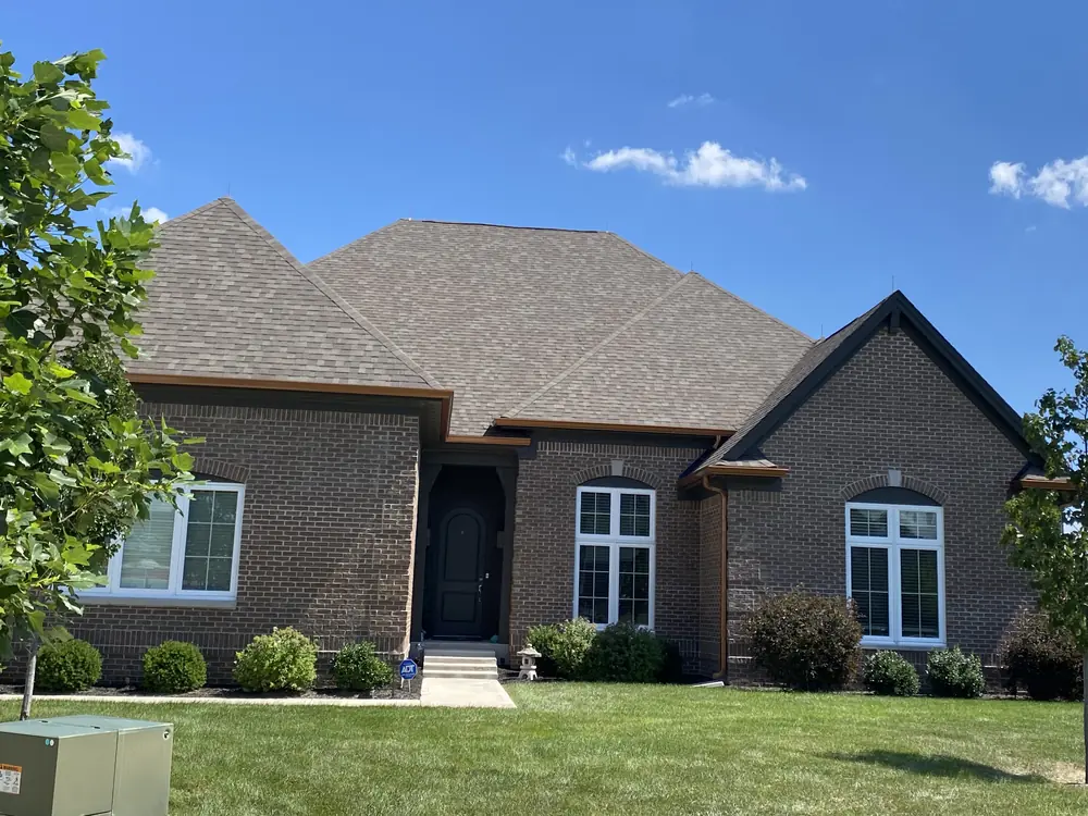 Brick ranch home with lightning air terminals spaced along the hip roof