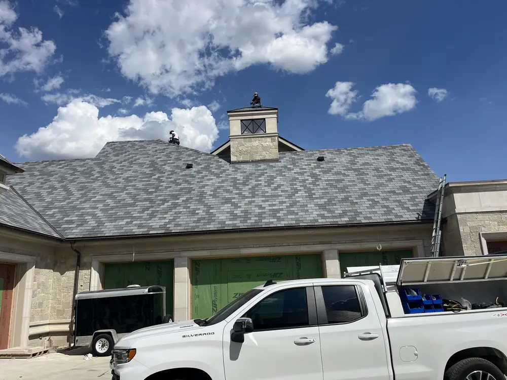 Lightning Rod Installers crew working the roof of a large stone home