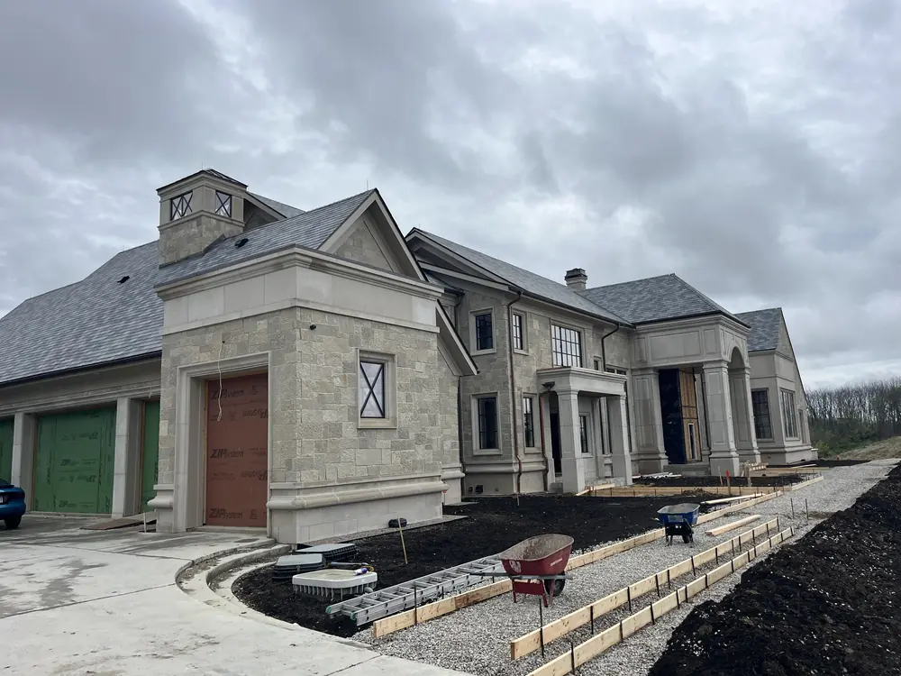 Large limestone home with a slate roof and a stone cupola