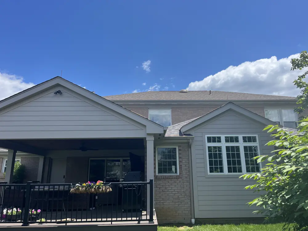 Rear elevation of a two-story home with a covered patio and a protected roofline