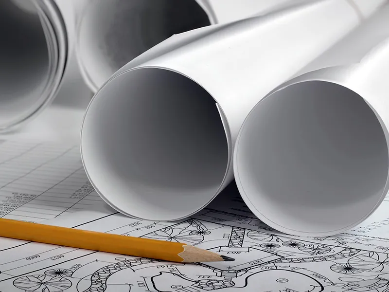 Rolled system design drawings and a pencil on a lightning protection layout plan
